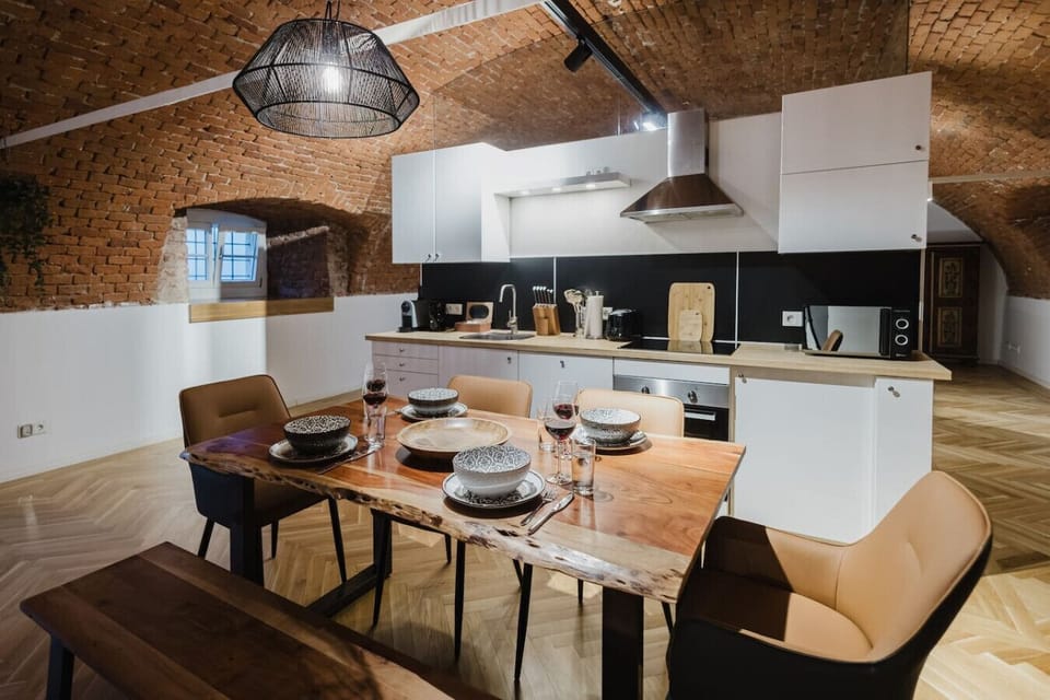 Charming dining area with artisanal wooden table and modern kitchen, perfect for family meals.