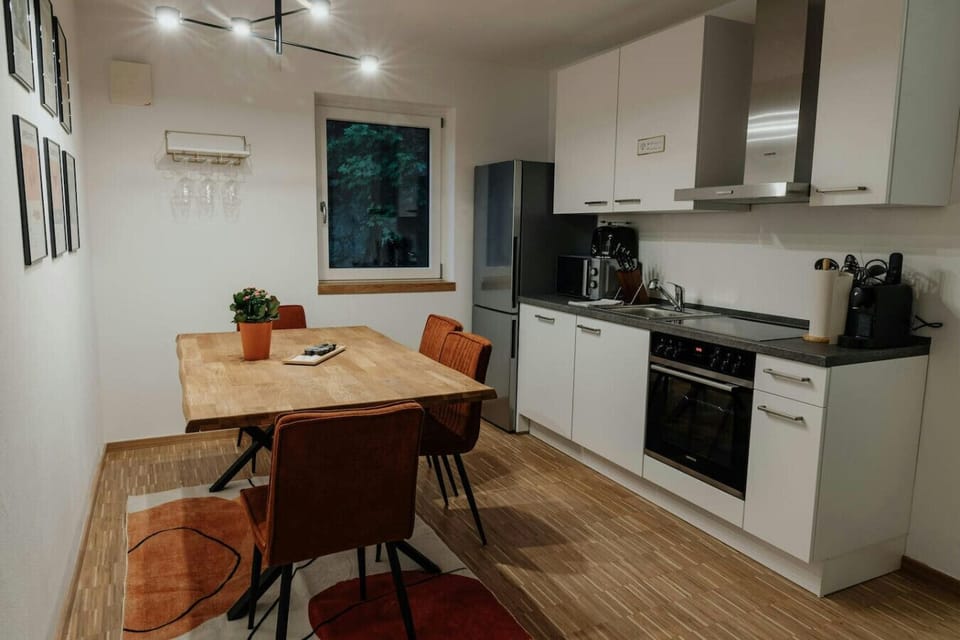 Fully equipped kitchen with sleek appliances and a charming dining nook – ideal for preparing and enjoying homemade meals.