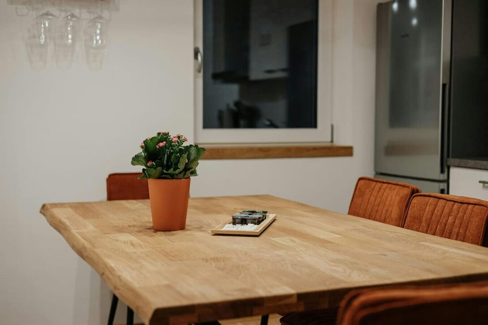 Charming dining area featuring a solid wood table, velvet chairs, and warm lighting – ideal for shared meals and cozy evenings.