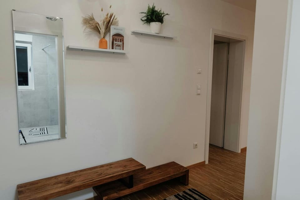 Welcoming entrance hall with mirror, wooden bench and subtle decor – your cozy first impression.