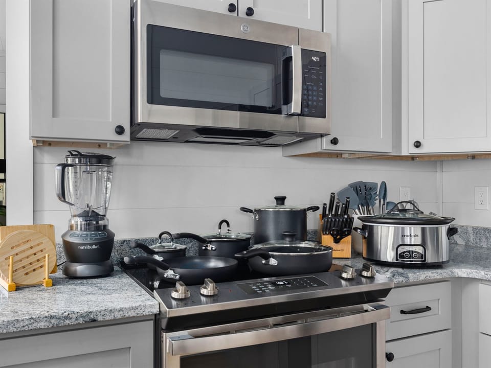 Cook like a pro with quality cookware, a powerful blender, slow cooker, and sharp chef knives. This kitchen is fully equipped for any meal.