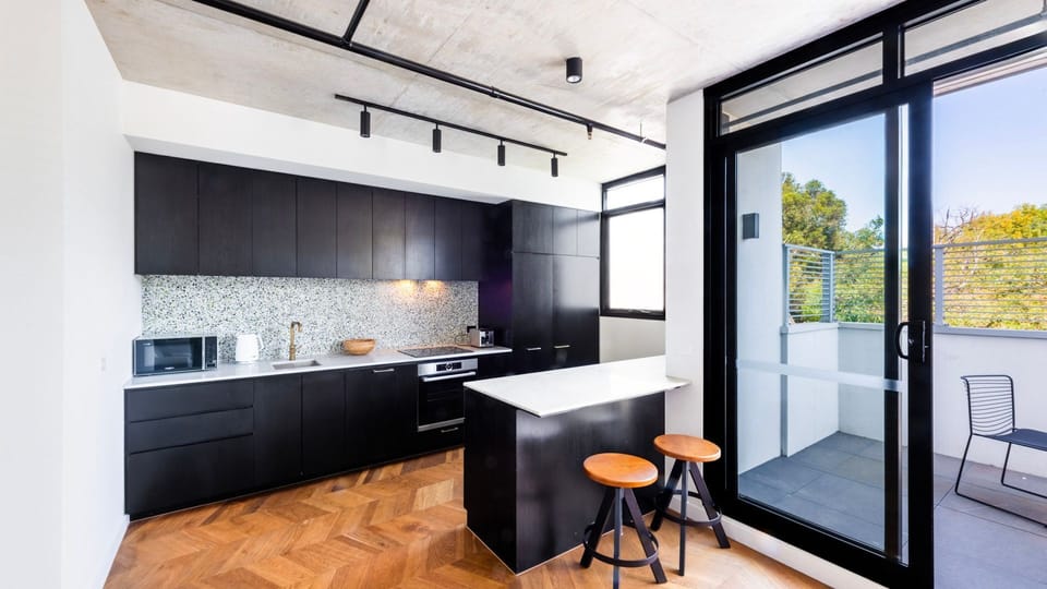 Modern black kitchen with elegant finishes and alfresco connection.