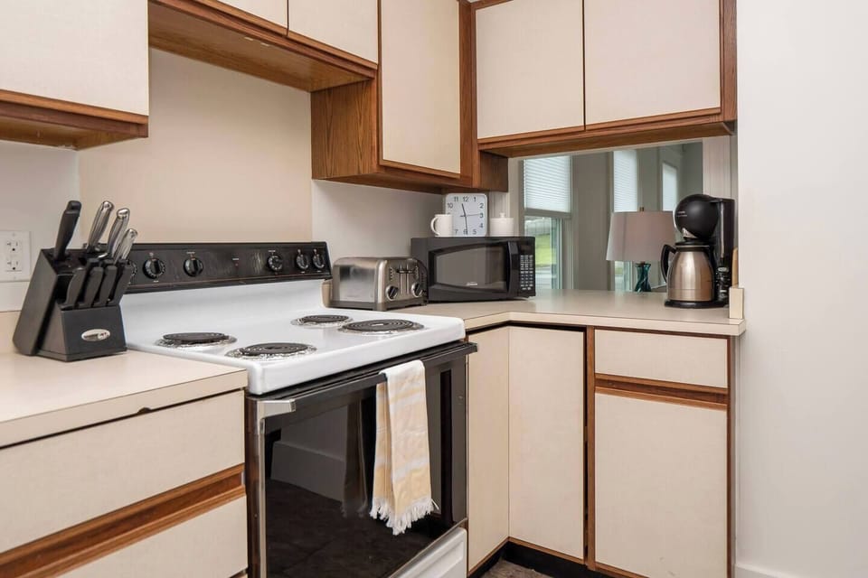Full kitchen with pots and pans, microwave, coffee maker and basic spices for cooking