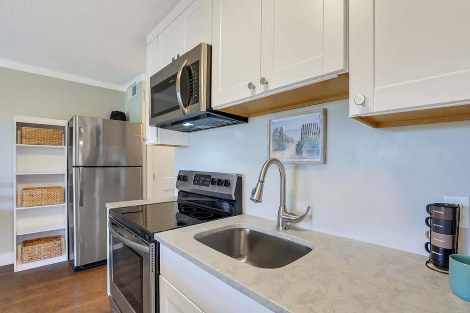 Bright modern kitchen with stainless steel appliances, quartz counters, and ample storage.

