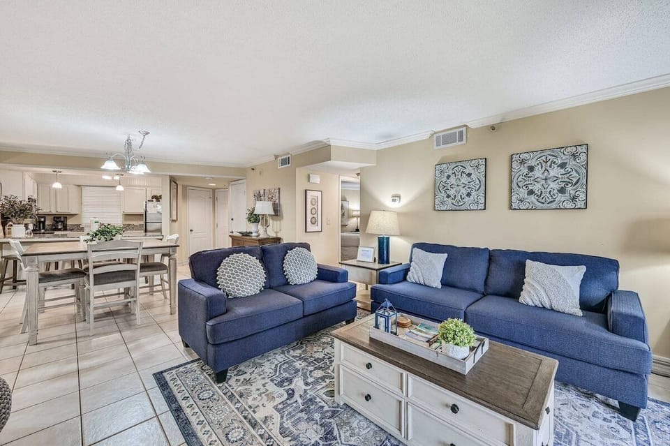 Open concept living area with TV balcony access and sleeper sofa