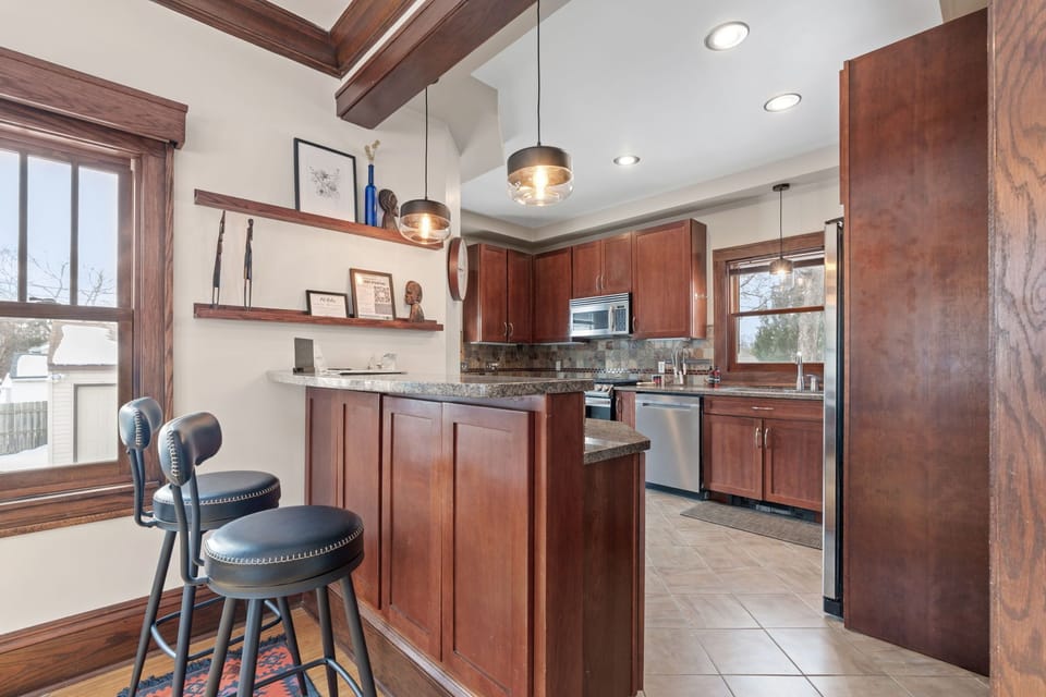 Cook your favorite meals in this fully-equipped kitchen with rich wood cabinetry, granite countertops, and modern appliances.