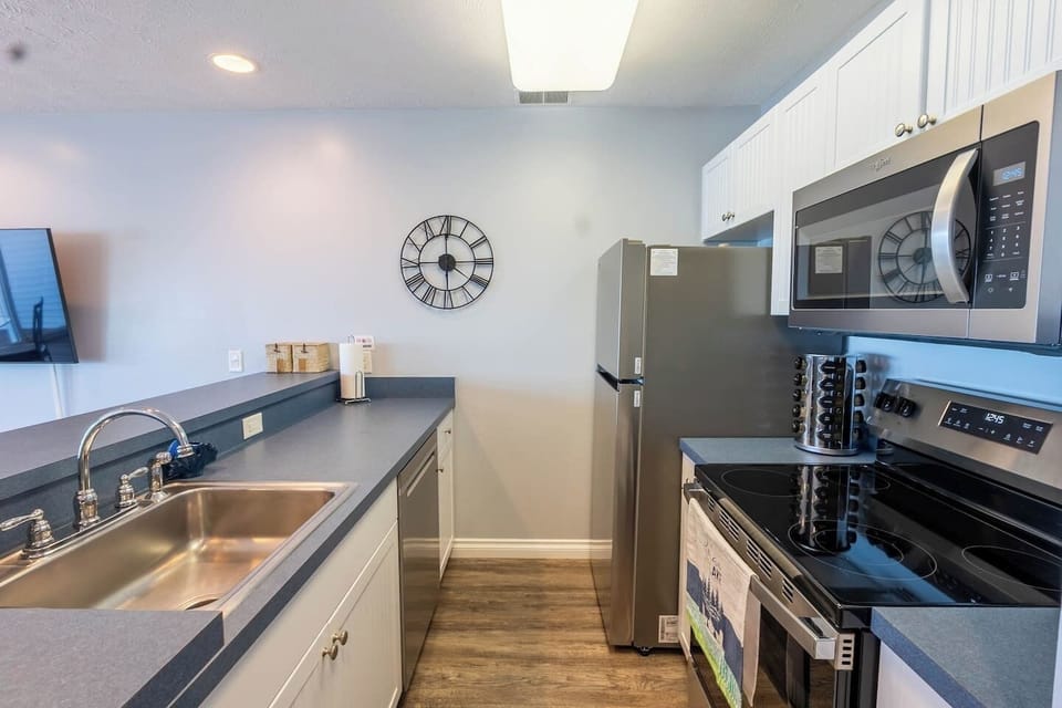 Full kitchen stocked with cups, plates, silverware, cooking utensils, and spice rack. Brita filtered water system in the fridge.