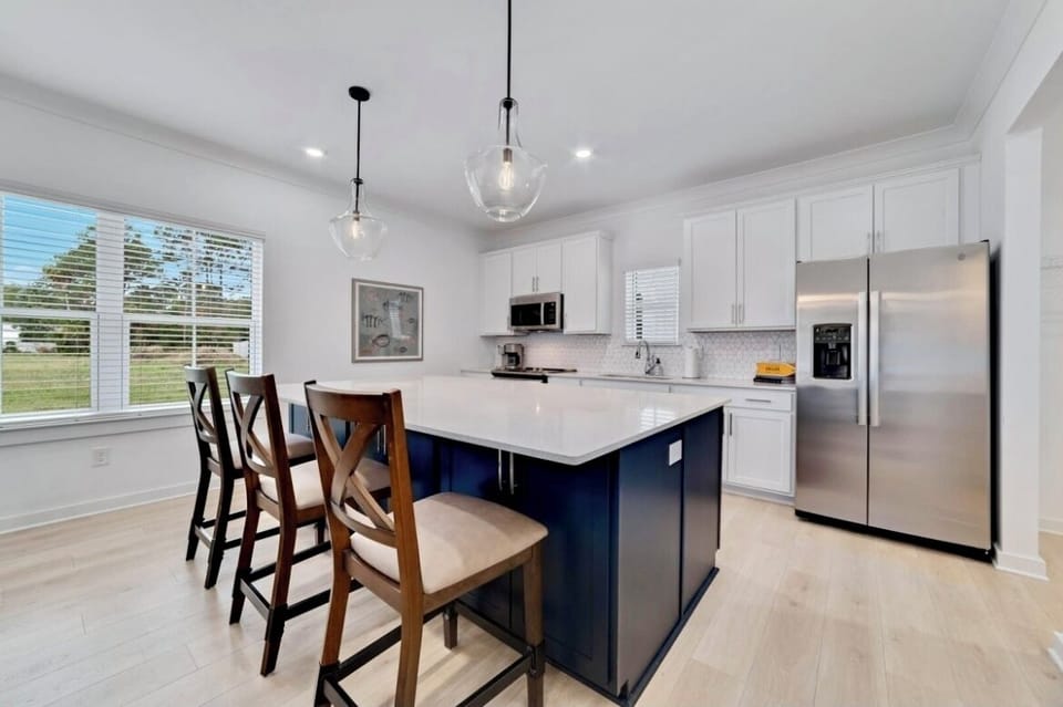 "The Orangery" boasts a sleek kitchen with a stylish island and cozy seating.