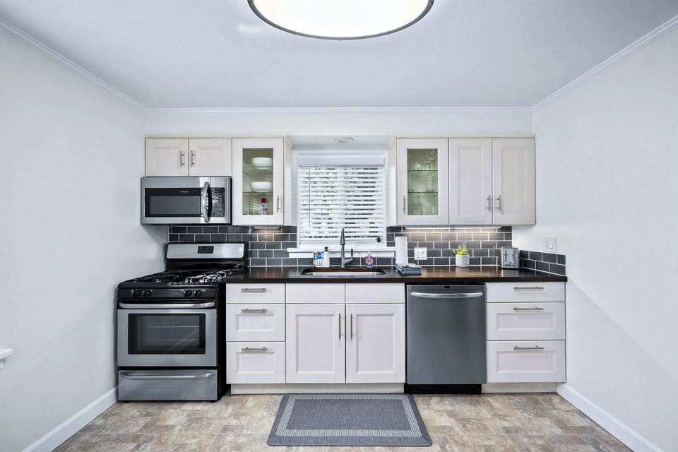 Your fully equipped kitchen features modern appliances and sleek white cabinetry, perfect for preparing meals during your stay.