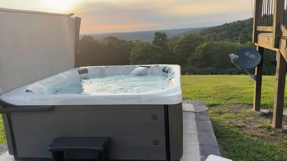 Soak in the private hot tub with panoramic Ozark views—perfect for unwinding after hiking or exploring the Buffalo National River.