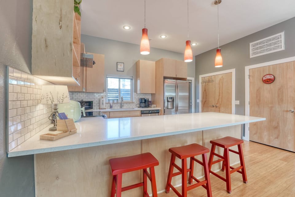Sleek kitchen island and barstools make dining casual and social; pendant lights add a warm glow.