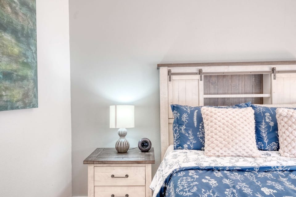 Elegant guest room with queen bed, plush pillows and a stylish headboard—perfect for peaceful nights.