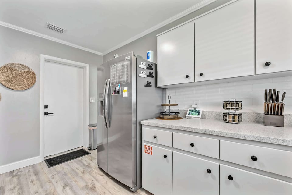 Modern kitchen area featuring a stainless steel refrigerator and organized countertop essentials.