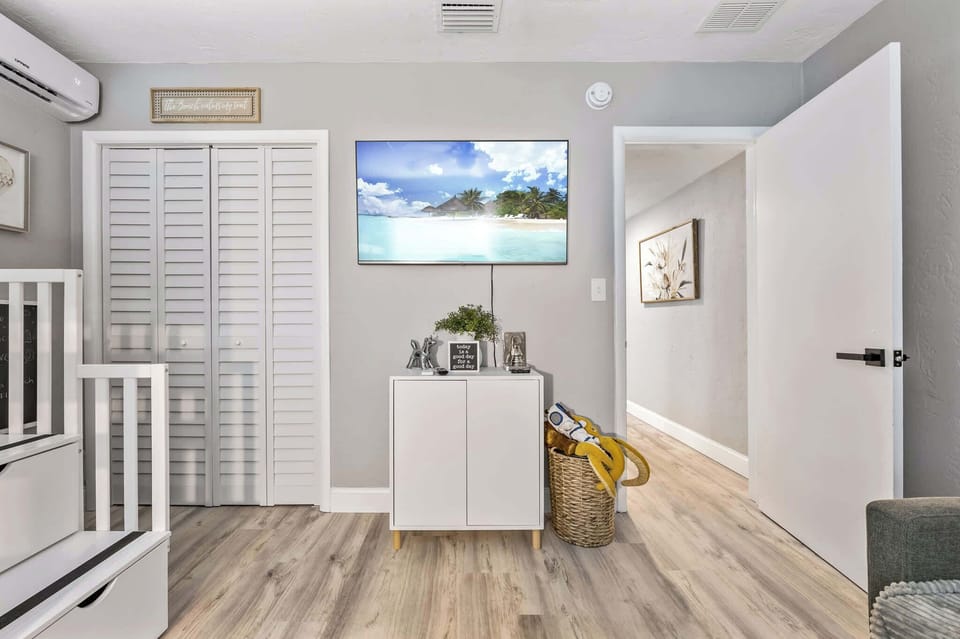 Modern room with a wall-mounted television and light wood flooring