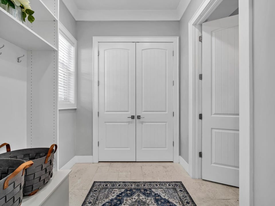 Your organized mudroom keeps everything tidy with built-in storage, hooks, and a charming entry rug that welcomes you home.