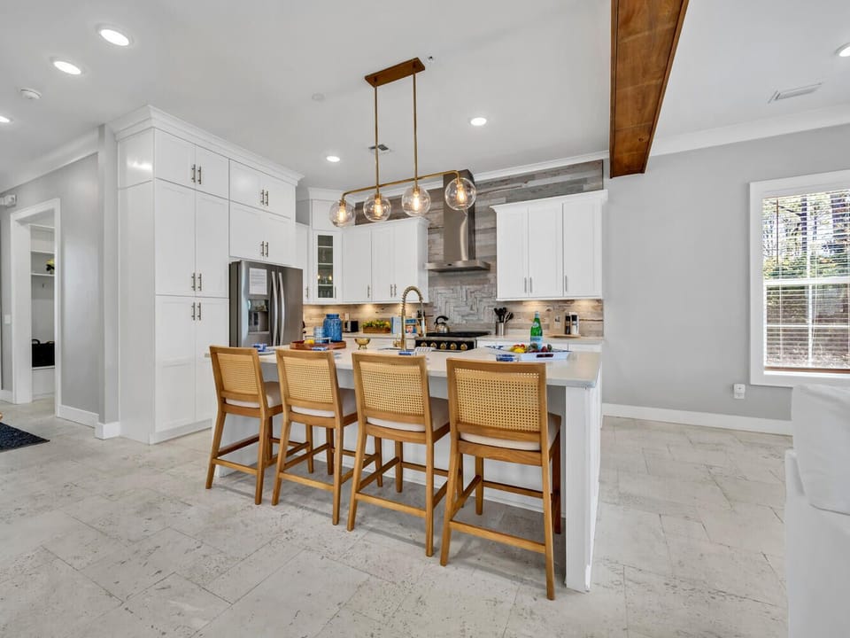 Your spacious kitchen features gleaming white cabinets, stainless steel appliances, and a beautiful island where you can prepare meals together.