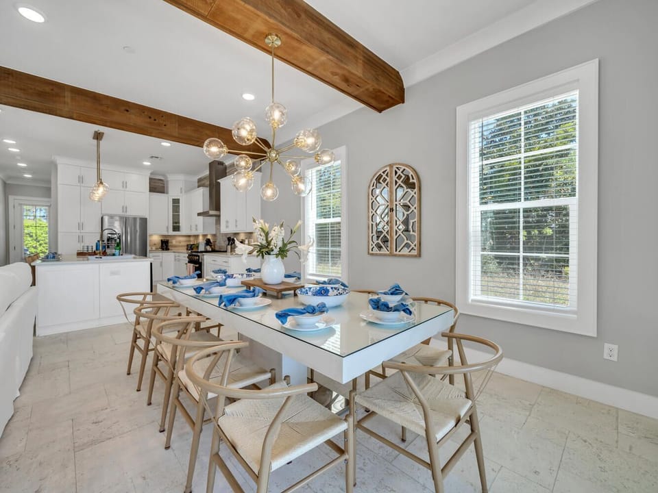 Gather around your elegant dining table under warm pendant lighting and rustic wood beams for memorable meals together.