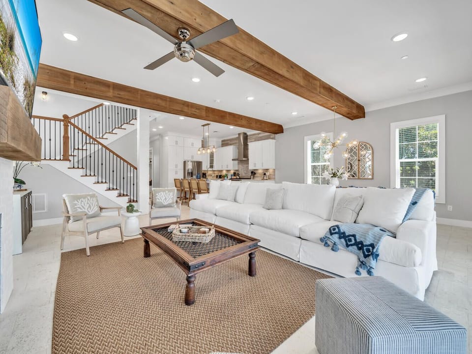 Sink into plush seating beneath rustic beams while natural light streams through your windows. The open layout connects you seamlessly to the gourmet kitchen.