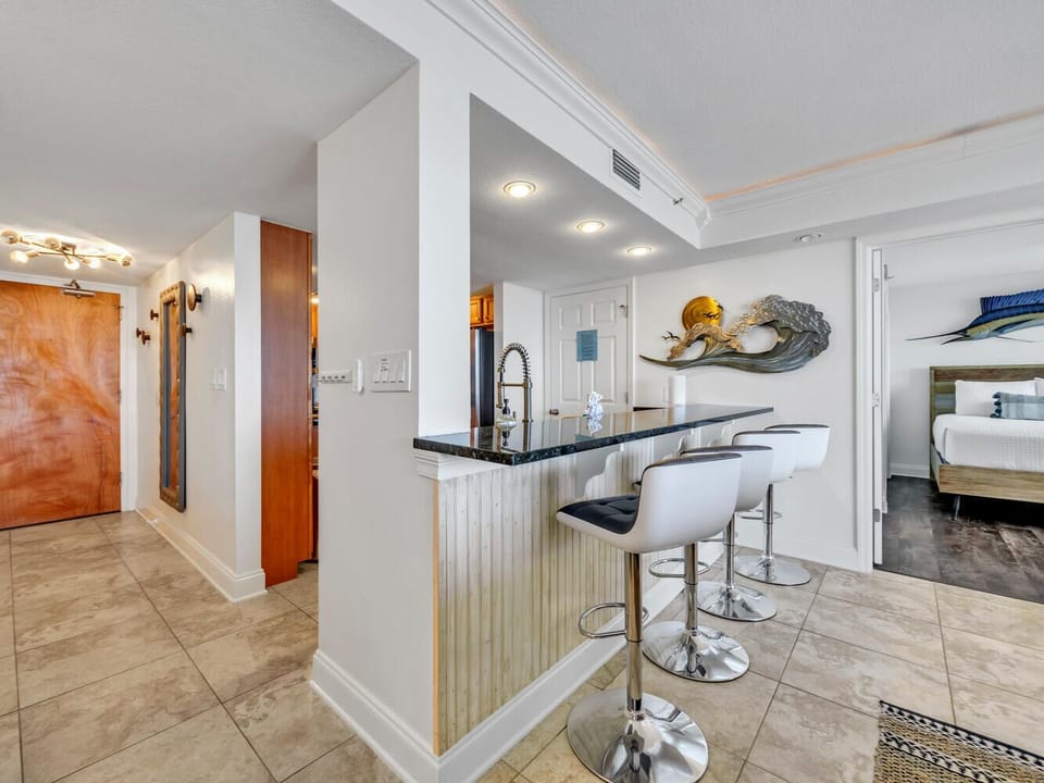 Gather around your stylish breakfast bar with sleek granite countertops and modern bar stools, perfect for morning coffee or casual meals.