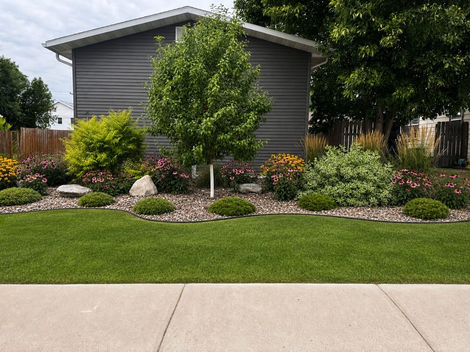 Beautifully landscaped yard with lush lawn and colorful garden beds