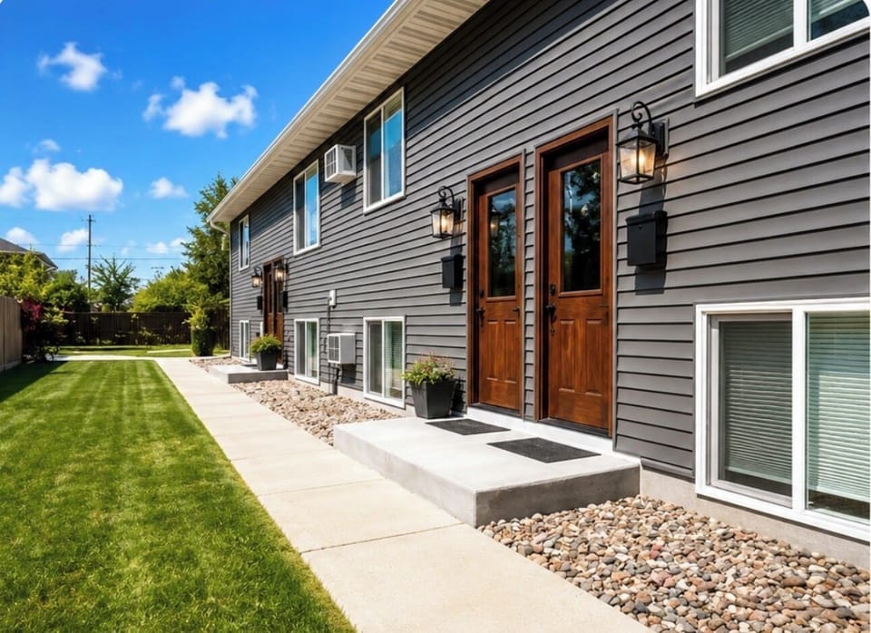 Private exterior entrance with well-kept walkway and landscaped lawn