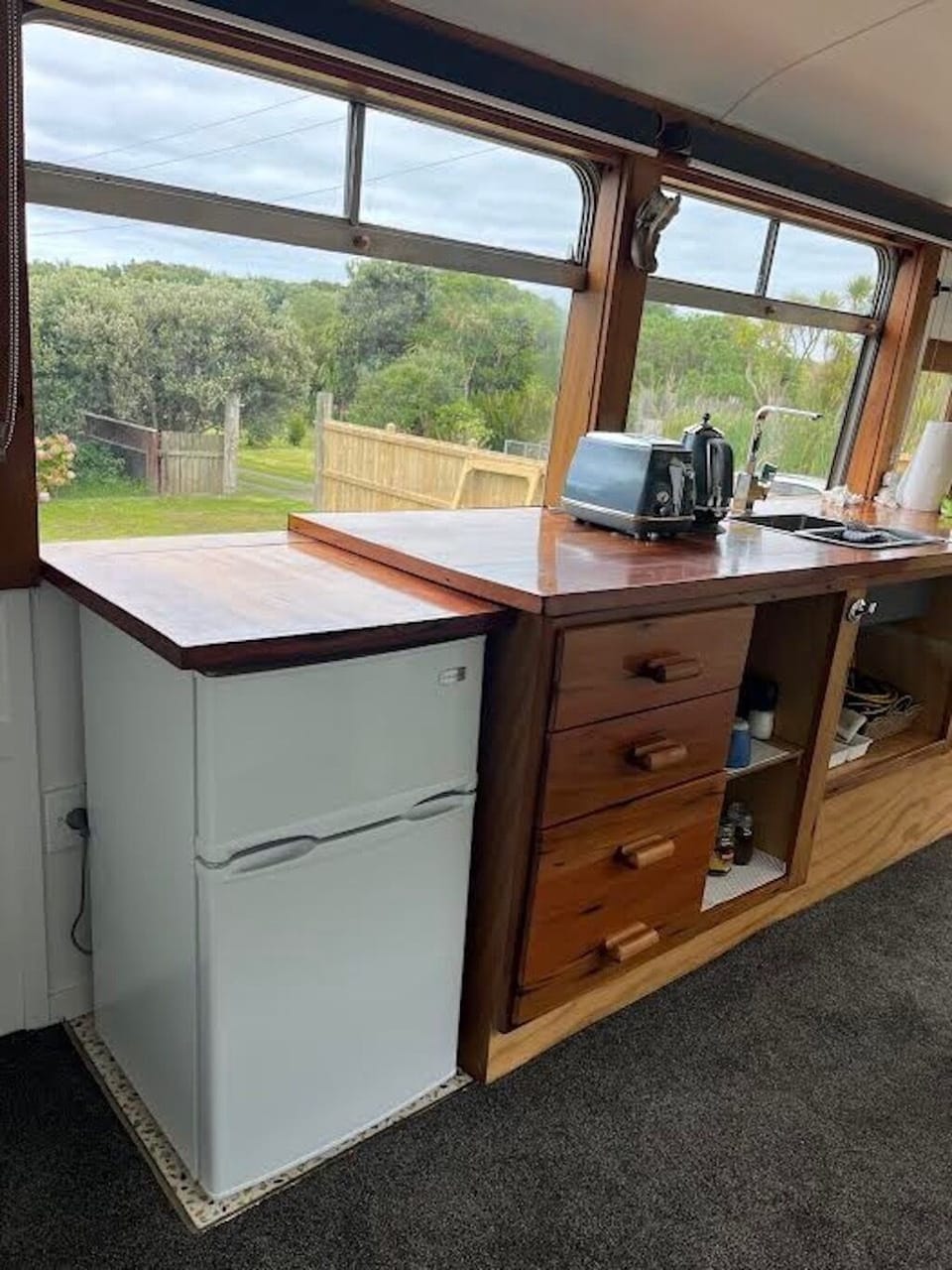 Kitchen area with microwave, toaster, jug, fridge.