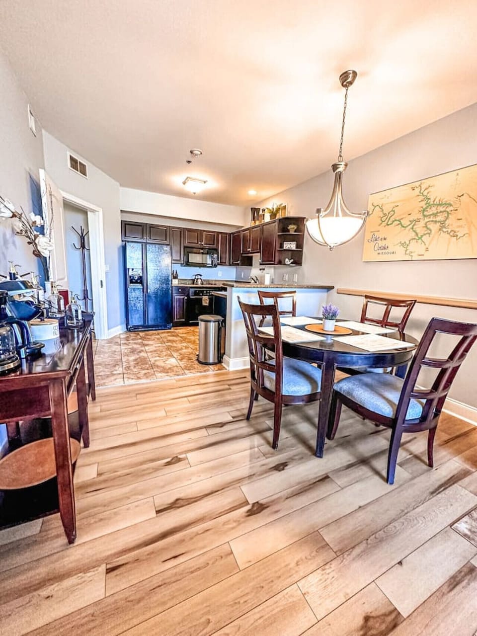 This elegant dining space features a large wooden table with comfortable chairs, perfect for memorable meals with family and friends. The room is beautifully illuminated by a rustic chandelier, creating a warm and inviting atmosphere for all your gat