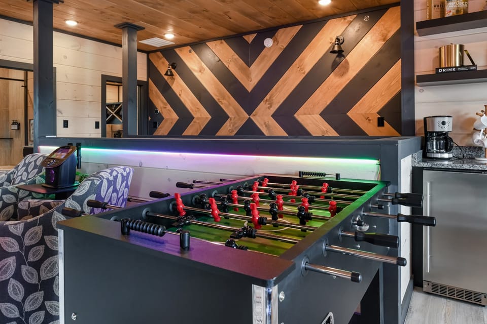 Game room with a foosball table and modern wood accent wall for entertaining.
