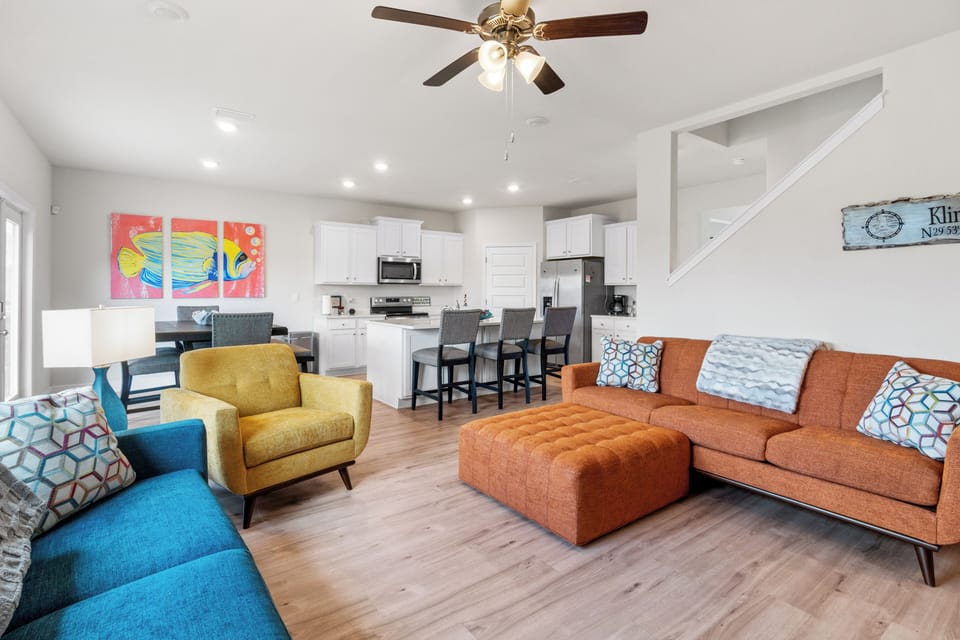 Unwind in this bright, modern living space with vibrant colors and comfortable seating flowing into your fully-equipped kitchen.