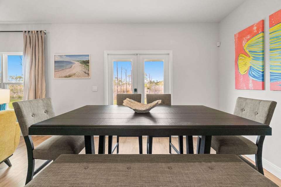 Gather around this spacious dining table where you'll share memorable meals with loved ones in the bright, art-filled space.
