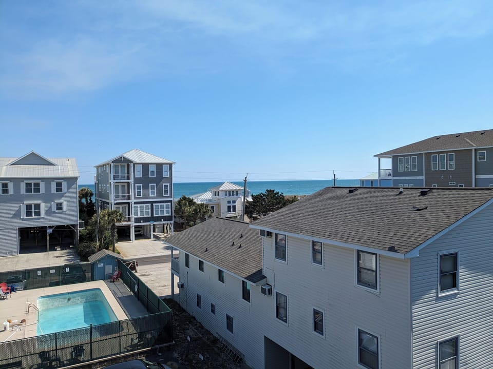 Unwind with this tranquil view of the ocean and the pool from the balcony. 