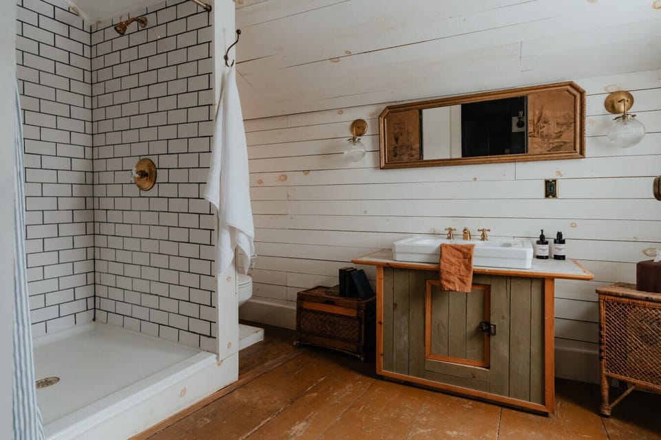 A stunning ensuite bathroom with double vanity, rustic wood finishes, and a walk-in shower. Thoughtfully designed to provide comfort and style.
