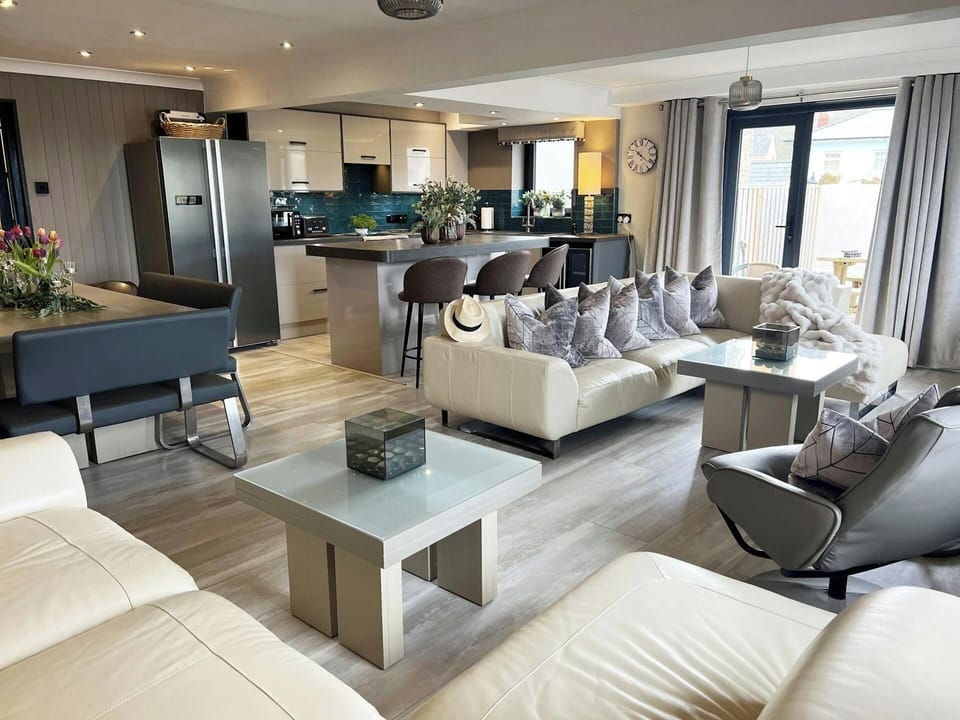 Graftons living room, sofas, coffee table, patio doors, kitchen and dining areas