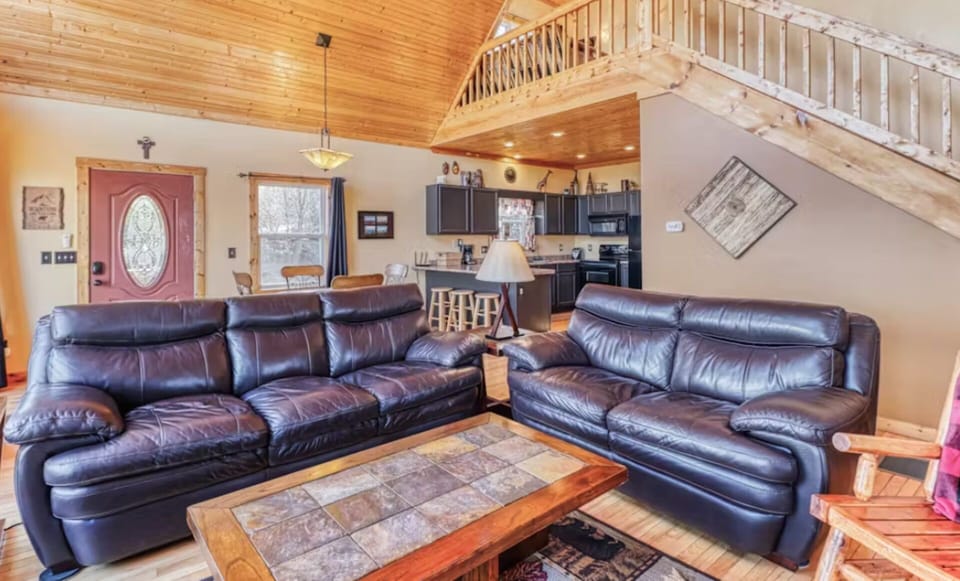 Cozy mountain cabin living room near Bryson City with leather seating, a fireplace, and scenic ridge views