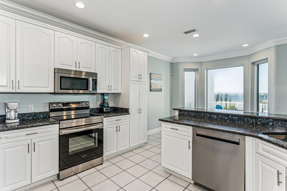 The kitchen features granite counters, a blender, coffee pot, and a Keurig