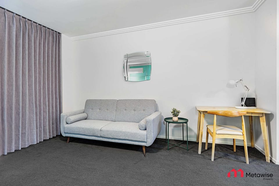 Additional angle of the sofa bed with work desk and wall décor.