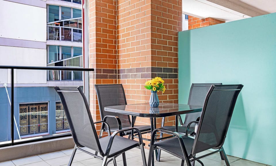 Private balcony with outdoor table and chairs.