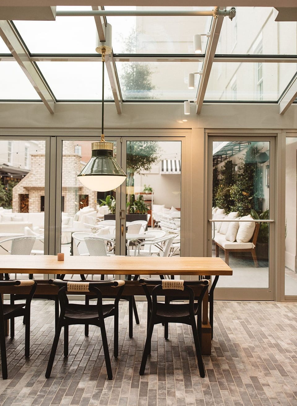 Serene sunlit dining space, where natural light and greenery set the scene for a relaxed and refreshing experience.