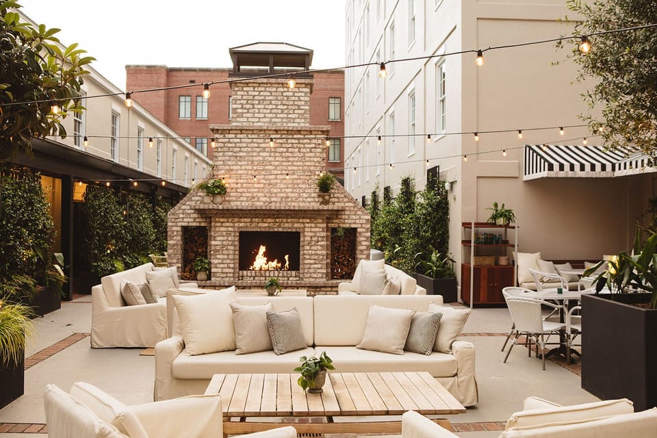 Charming outdoor retreat, where plush seating and a grand brick fireplace create the perfect setting for relaxation and conversation.
