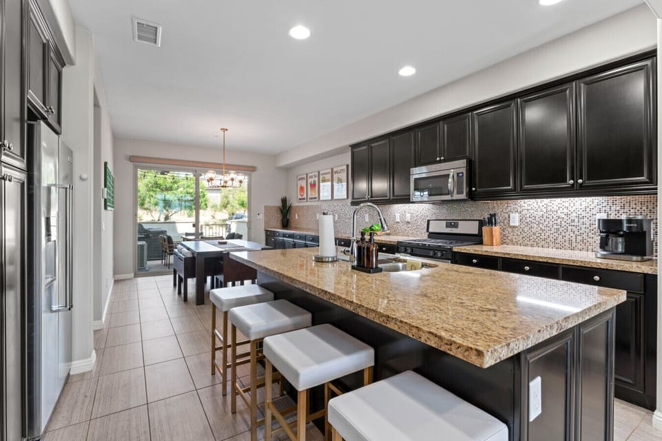 Sleek kitchen w/ granite island, bar seating & open flow to dining area