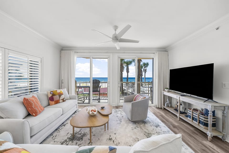 Living Room – A bright and spacious living area with cozy seating, a large flat-screen TV, and floor-to-ceiling windows offering stunning ocean views.