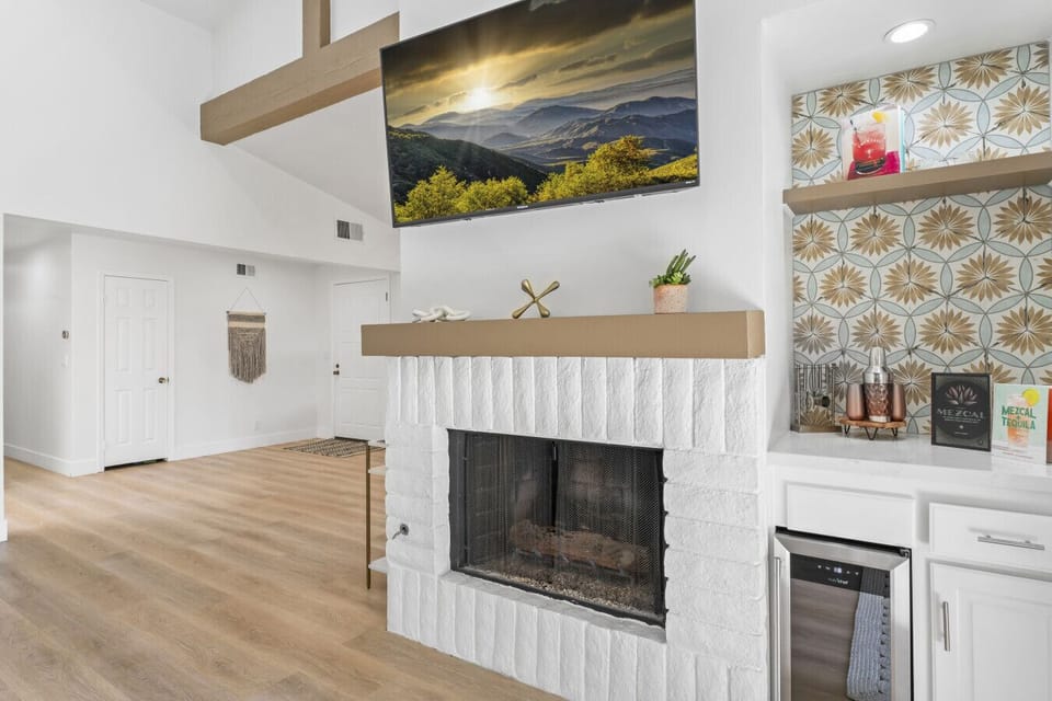 Cozy lounge w/ fireplace, mounted TV & floating shelves for relaxed evenings in