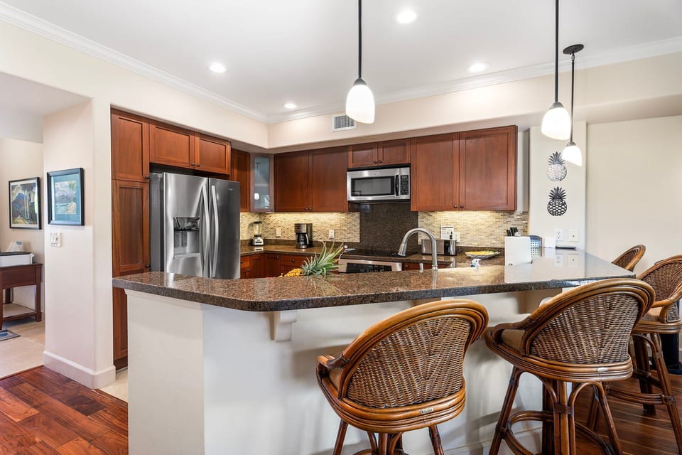 Fully Equipped Kitchen with Stainless Steel Appliances and Bar Seating