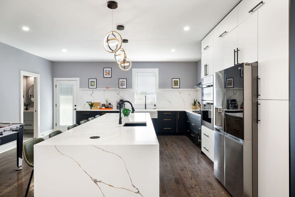Fully stocked modern kitchen with double ovens, large island & sleek finishes