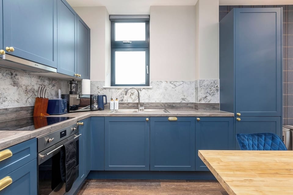 Modern kitchen featuring a stove top, dishwasher, washer/dryer, Nespresso machine, fridge/freezer, oven and microwave.