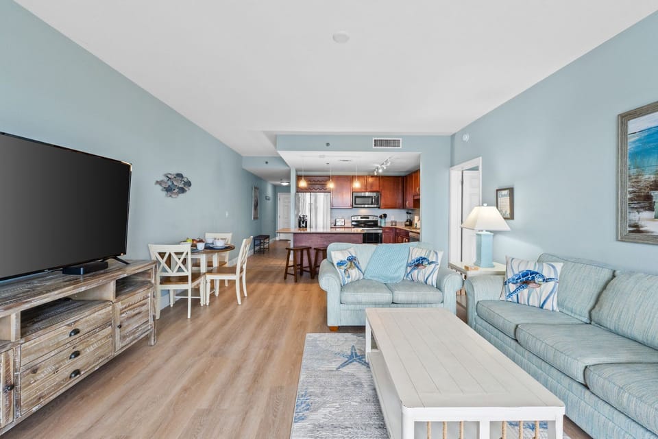 open living area with coastal-inspired decor and a view into the kitchen