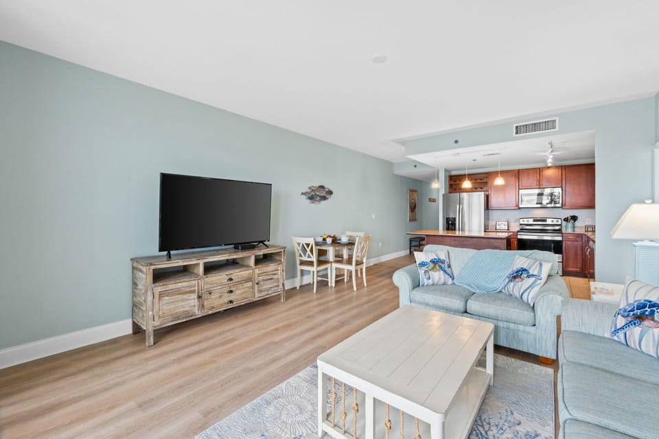 Open living area with coastal-inspired decor and a fully equipped kitchen