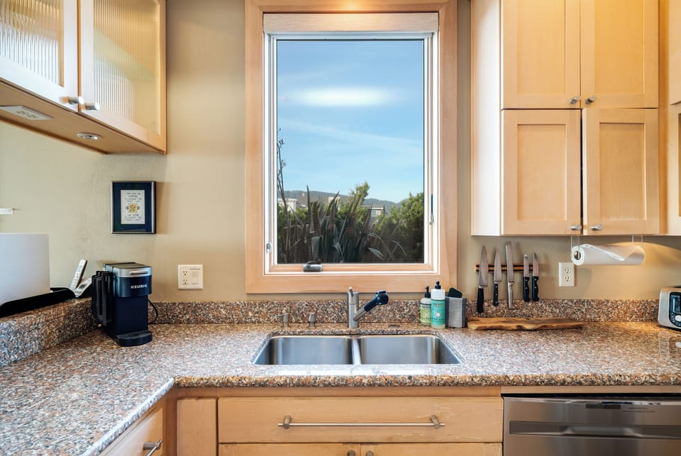 Ocean view fully equipped kitchen with breakfast bar, gas range, dishwasher, full fridge and microwave.