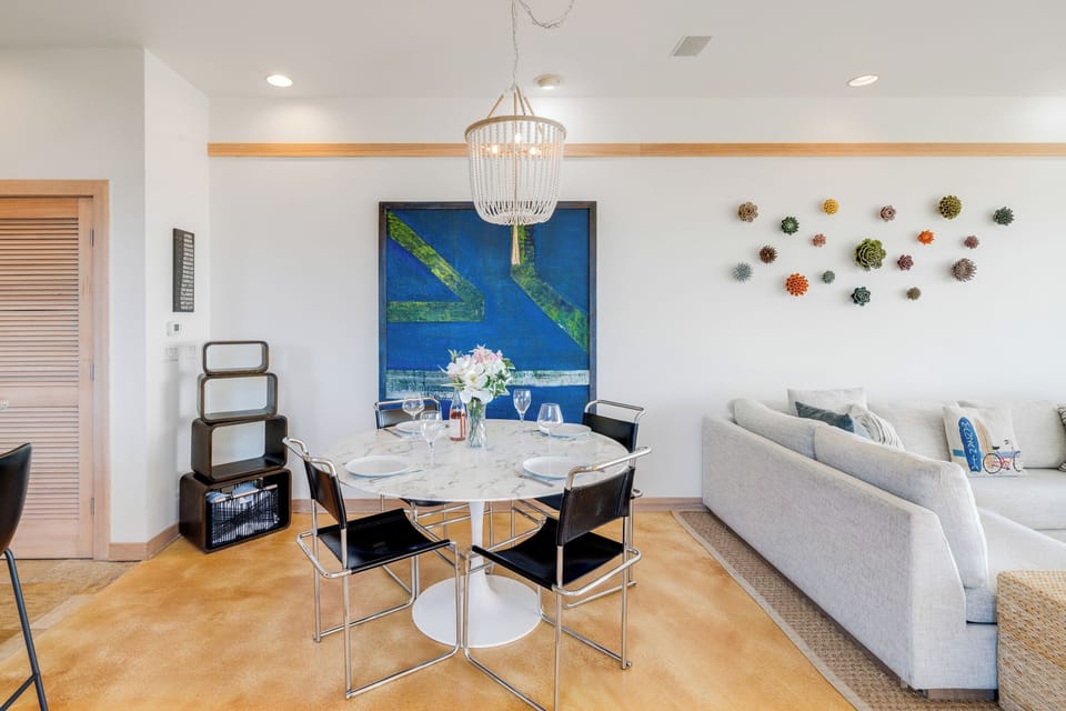 Ocean view dining room open to living room with gas fireplace, Dish and streaming TV, French doors to outside.