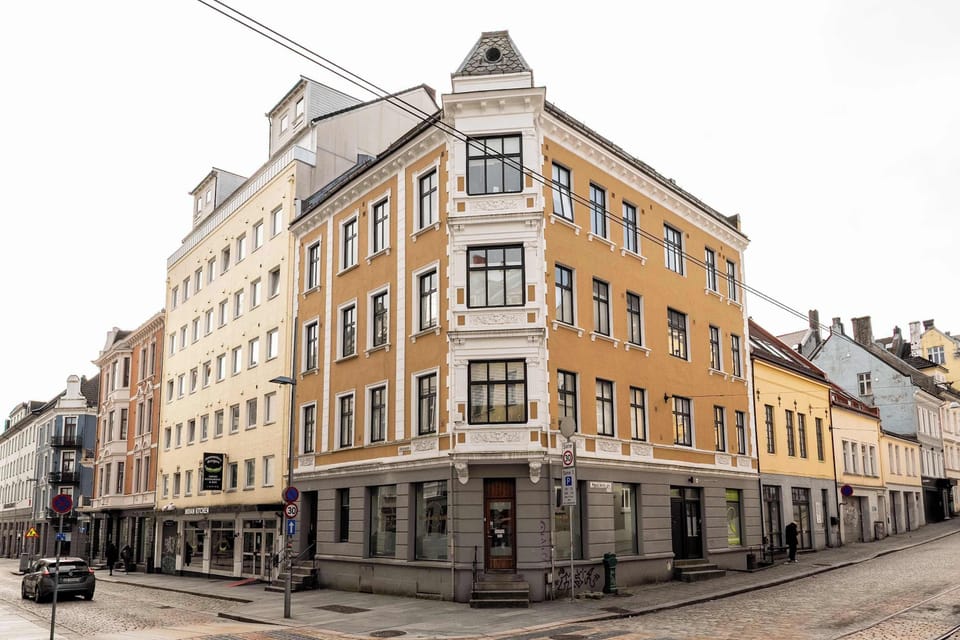 The corner building, with its intricate details and rich color, is a focal point of the city street.